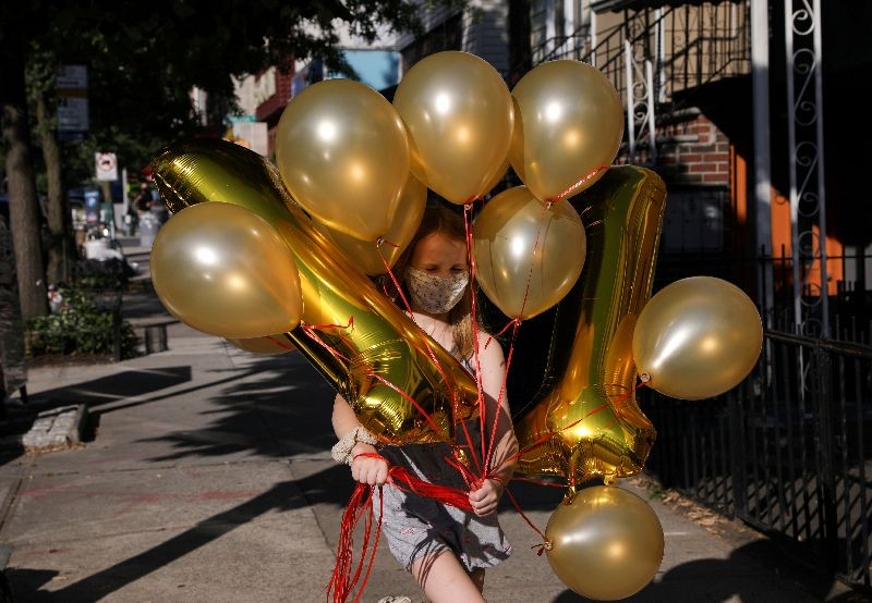 Lydia Hassebroek carries balloons for her birthday party in Brooklyn as New York slowly reopens during the continued outbreak of the coronavirus disease (COVID-19) in Brooklyn, New York, U.S., July 12, 2020. REUTERS/Caitlin Ochs
